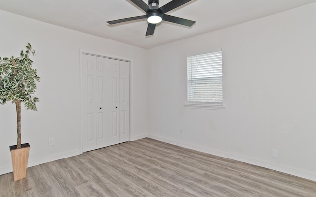 unfurnished bedroom with baseboards, a closet, and light wood-style flooring
