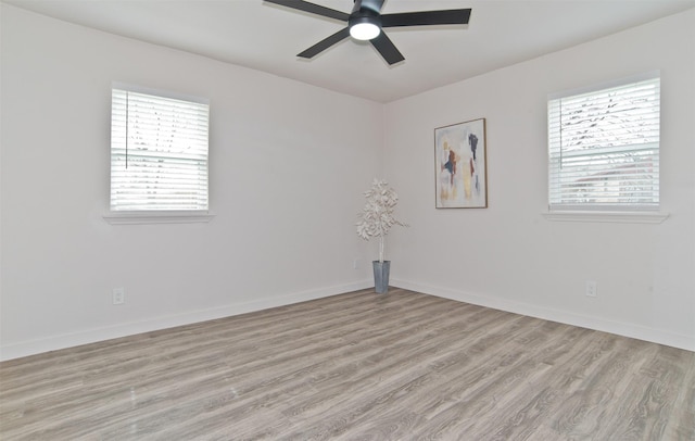 spare room with light wood finished floors, ceiling fan, and baseboards