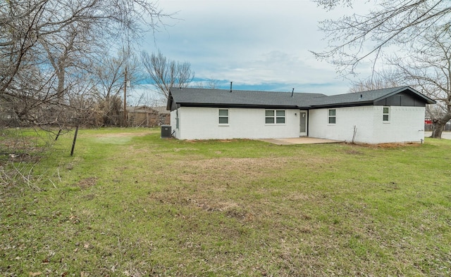 rear view of house featuring brick siding, a patio, and a lawn