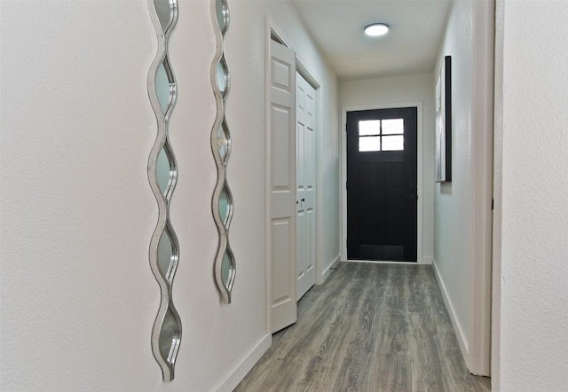 doorway to outside with dark wood-style floors and baseboards