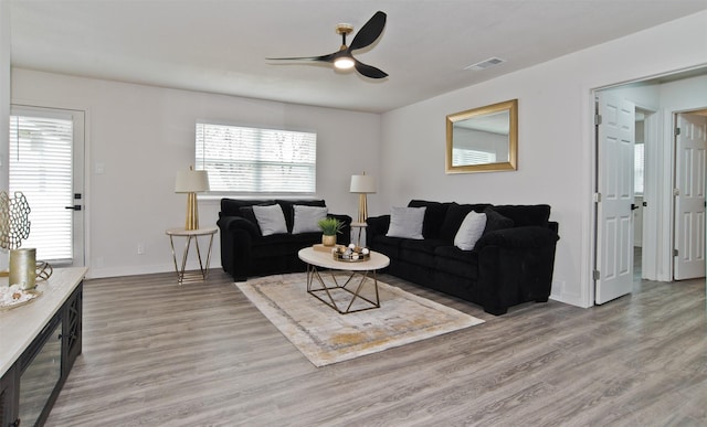 living area featuring plenty of natural light, visible vents, and ceiling fan
