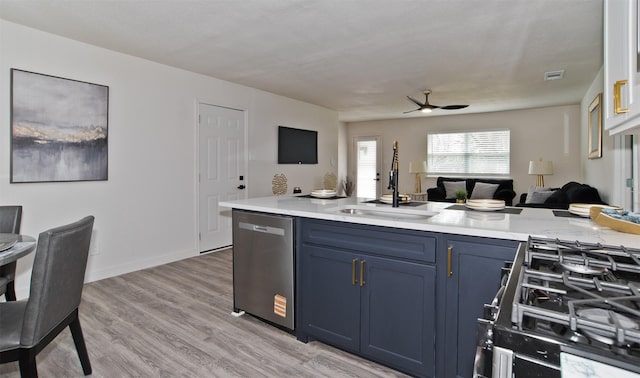kitchen featuring light countertops, a sink, open floor plan, ceiling fan, and dishwasher