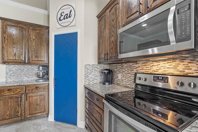 kitchen with light stone counters, dark brown cabinetry, stainless steel appliances, backsplash, and crown molding