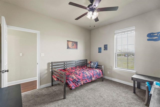 carpeted bedroom with a ceiling fan and baseboards