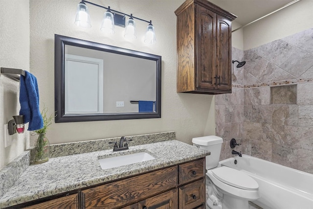 bathroom with a textured wall, shower / bathing tub combination, vanity, and toilet