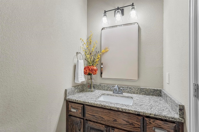 bathroom featuring a textured wall and vanity