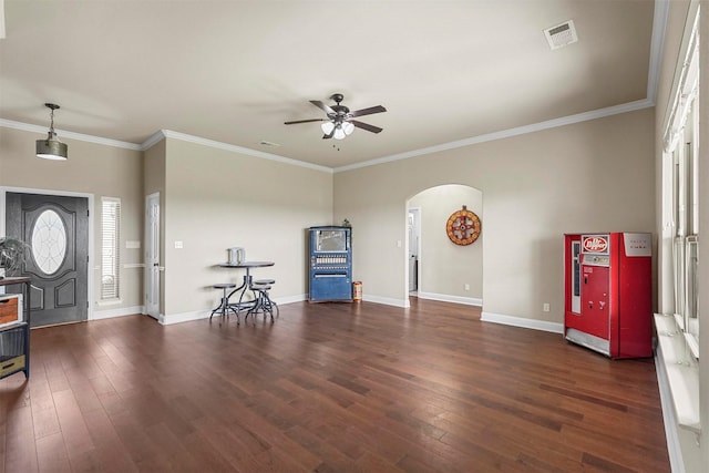 entryway featuring arched walkways, wood finished floors, visible vents, baseboards, and ornamental molding