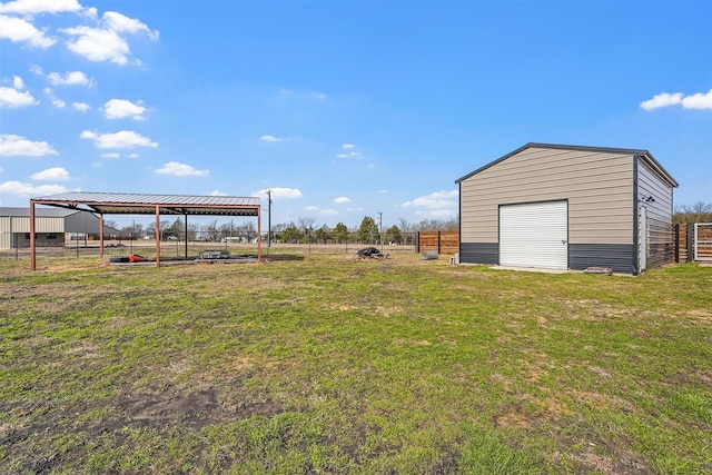 view of yard with a carport, an outdoor structure, and fence