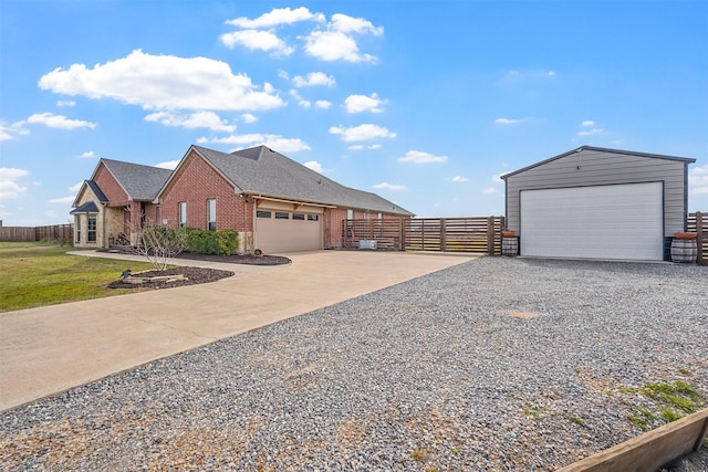 view of property exterior with a yard, brick siding, fence, and a detached garage