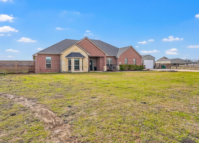 view of front of house with a front lawn, fence, and brick siding