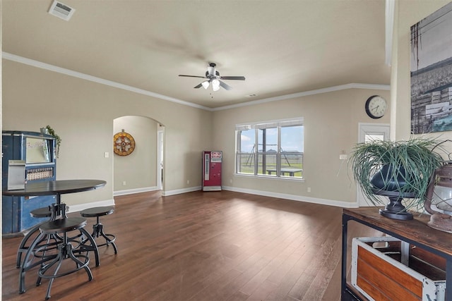 interior space with arched walkways, dark wood-style flooring, visible vents, baseboards, and crown molding