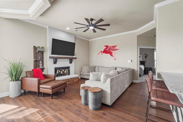 living room featuring ornamental molding, a brick fireplace, and wood finished floors