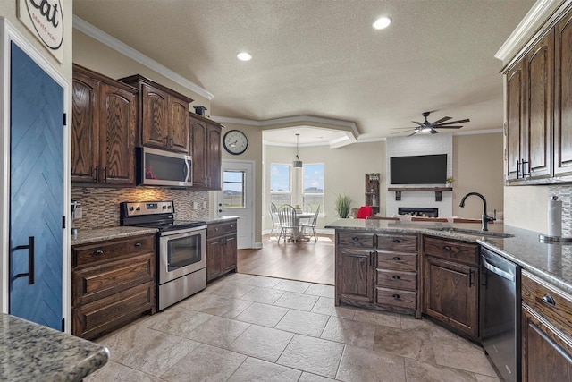 kitchen featuring a sink, dark brown cabinets, ornamental molding, appliances with stainless steel finishes, and tasteful backsplash