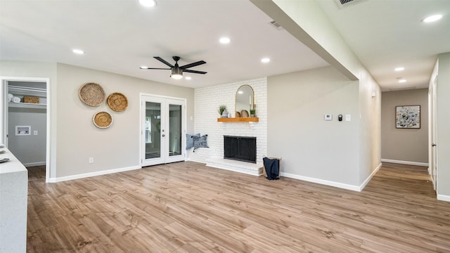 unfurnished living room featuring light wood-style flooring, a fireplace, french doors, and recessed lighting