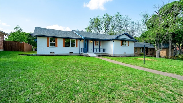 ranch-style home with brick siding, fence, roof with shingles, crawl space, and a front lawn