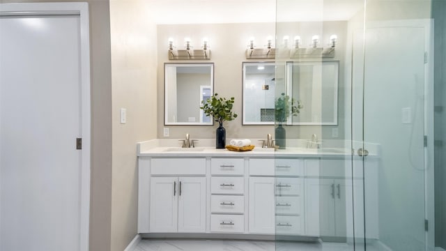 full bath with a sink, a shower stall, baseboards, and double vanity