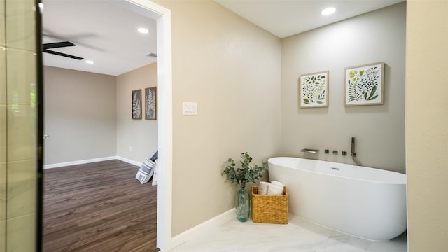 full bathroom with a soaking tub, visible vents, baseboards, and a ceiling fan