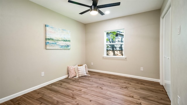 unfurnished room featuring wood finished floors, a ceiling fan, and baseboards