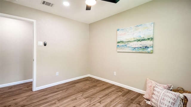 empty room with baseboards, visible vents, ceiling fan, and wood finished floors