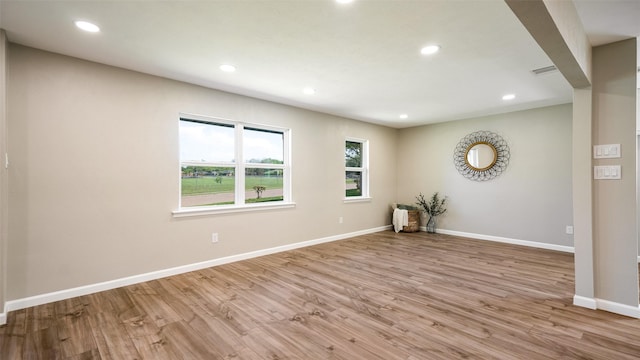 empty room with recessed lighting, wood finished floors, visible vents, and baseboards