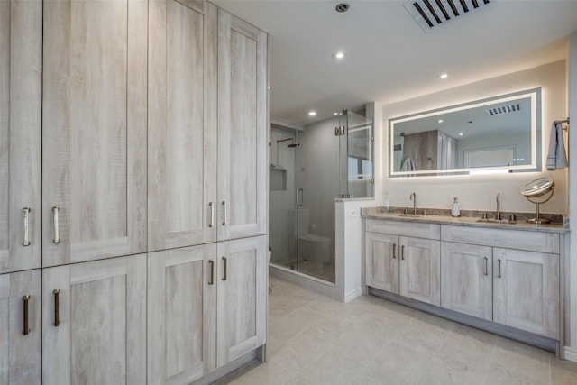 full bath with visible vents, a shower stall, and a sink