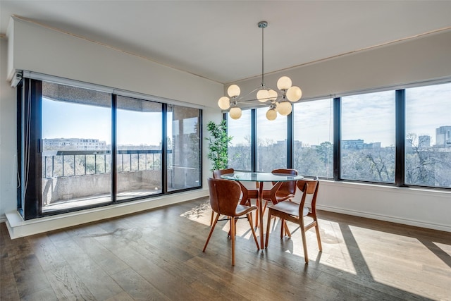 dining area featuring wood finished floors, a city view, and a chandelier