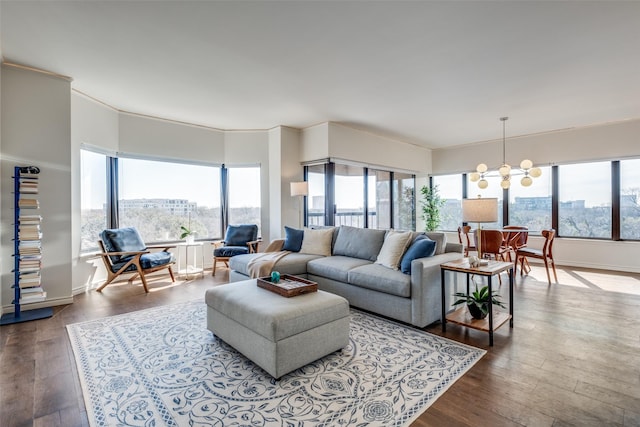 living area featuring plenty of natural light, dark wood-style flooring, and a chandelier