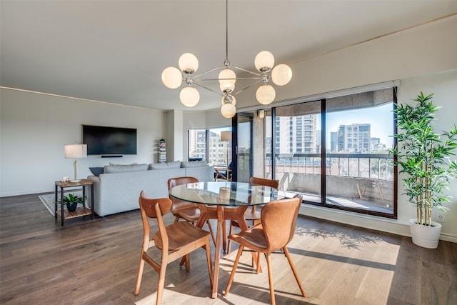 dining area featuring an inviting chandelier, wood finished floors, and baseboards