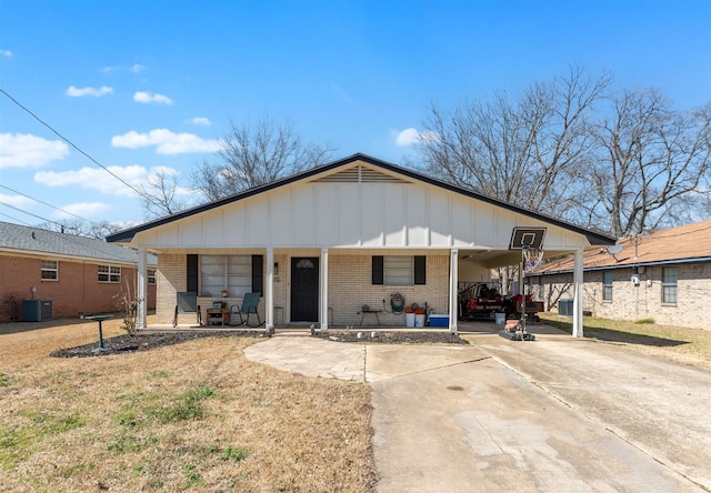 view of front of home featuring an attached carport, a porch, brick siding, driveway, and board and batten siding