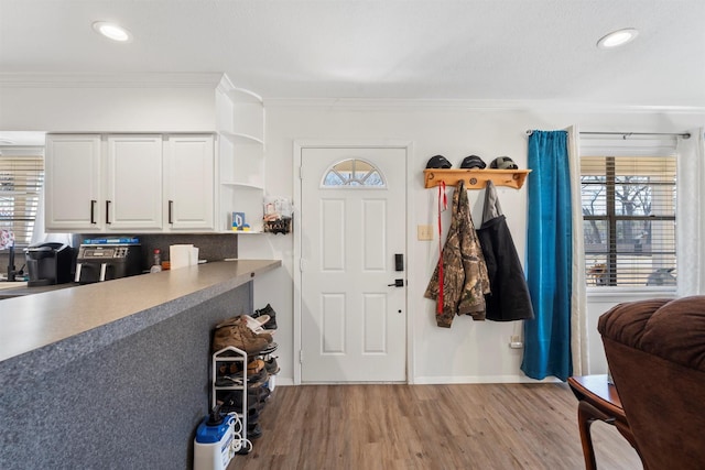 entrance foyer featuring a wealth of natural light, crown molding, recessed lighting, and wood finished floors