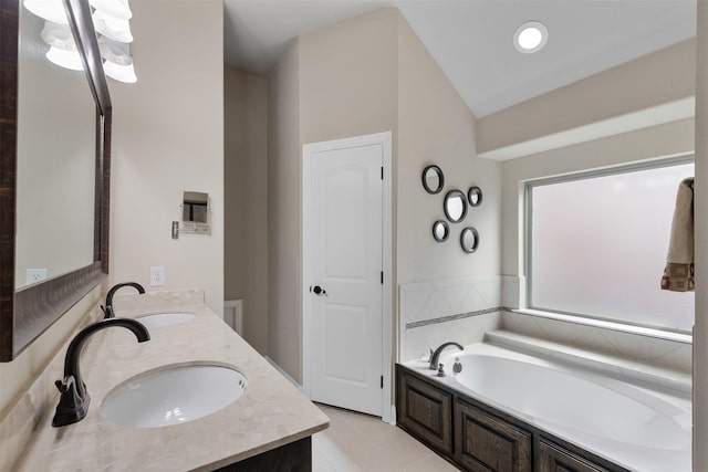 bathroom featuring vaulted ceiling, a sink, a bath, and double vanity