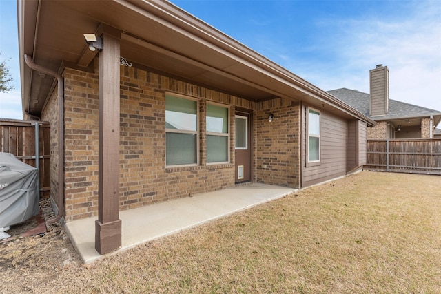 rear view of property featuring a yard, fence, and brick siding