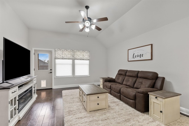 living room with lofted ceiling, baseboards, a ceiling fan, and dark wood-type flooring