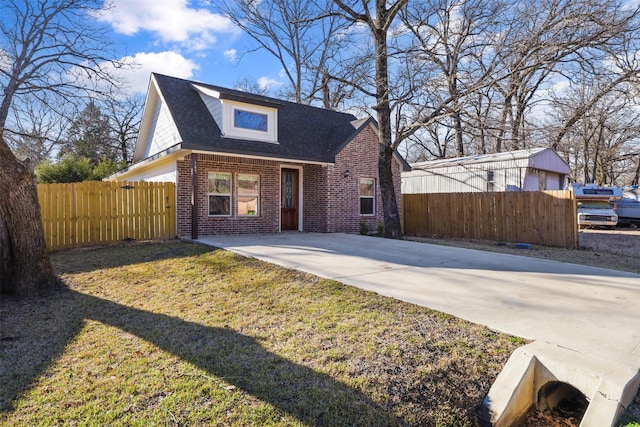 view of front of property featuring a shingled roof, fence, and brick siding