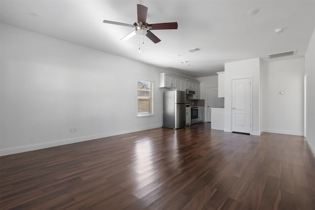 unfurnished living room with baseboards, visible vents, a ceiling fan, and dark wood-type flooring