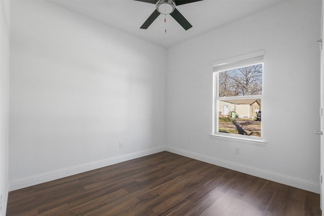 spare room featuring ceiling fan, baseboards, and dark wood-type flooring