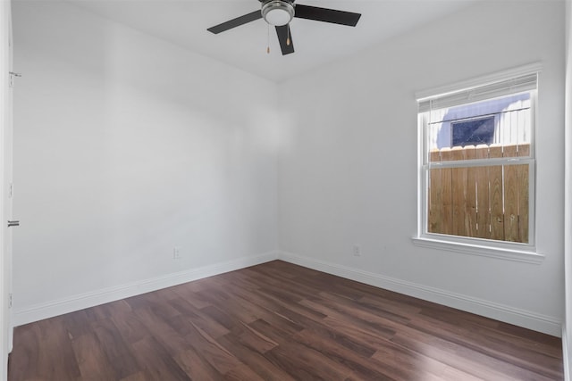 spare room with wood finished floors, a ceiling fan, and baseboards