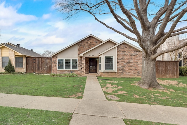 mid-century home featuring a front yard, brick siding, and fence