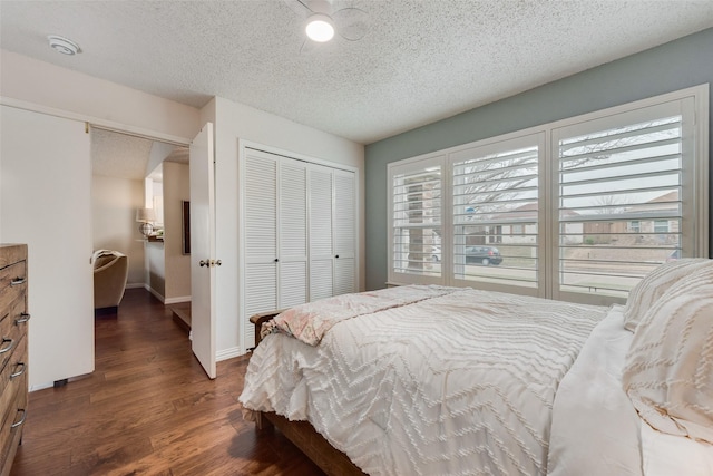 bedroom featuring a textured ceiling, baseboards, a closet, and wood finished floors