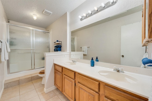 bathroom featuring a stall shower, tile patterned flooring, visible vents, and a sink