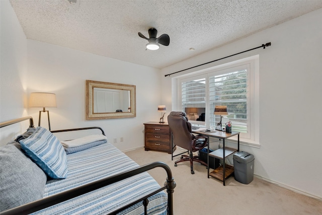 carpeted bedroom featuring a ceiling fan, baseboards, and a textured ceiling