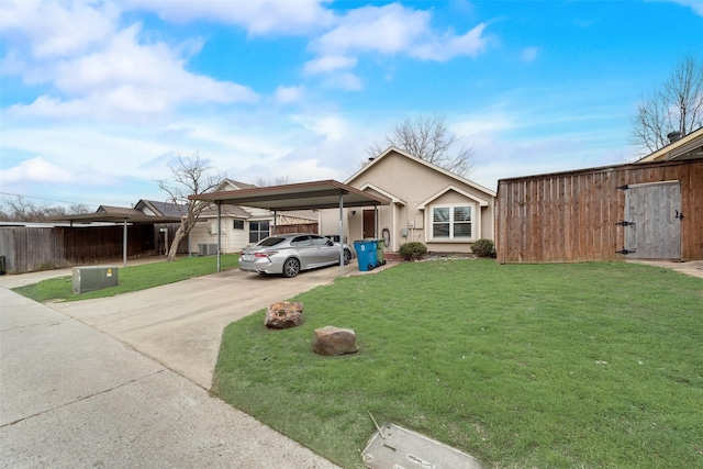 view of front of house with an attached carport, concrete driveway, fence, and a front lawn