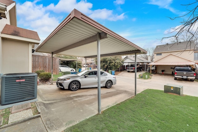 view of parking / parking lot with fence and a detached carport