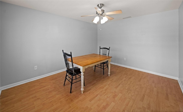 dining room with light wood finished floors, baseboards, and visible vents