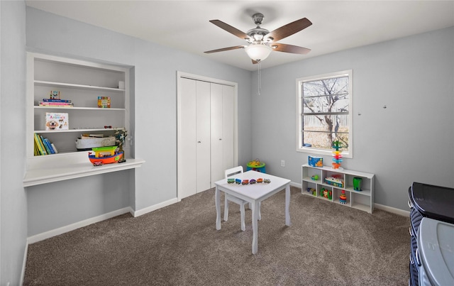 recreation room with carpet floors, ceiling fan, and baseboards