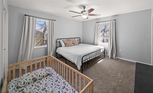 carpeted bedroom with ceiling fan and baseboards