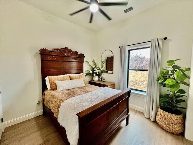 bedroom featuring visible vents, ceiling fan, light wood-style flooring, and baseboards