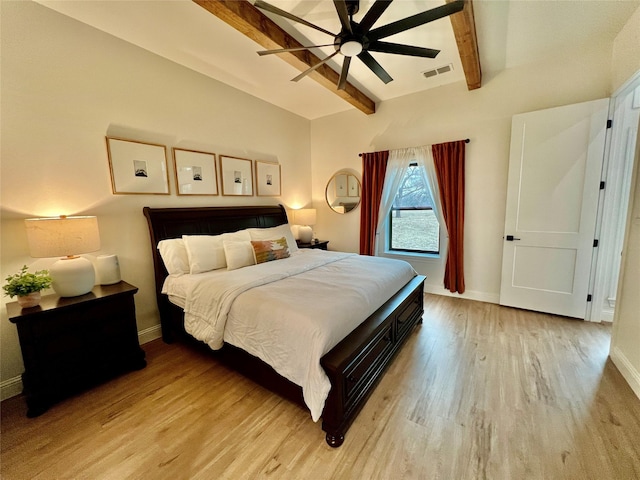 bedroom featuring baseboards, visible vents, lofted ceiling with beams, ceiling fan, and light wood-style floors