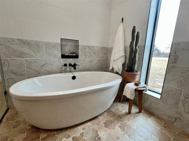 bathroom with a freestanding tub and tile walls