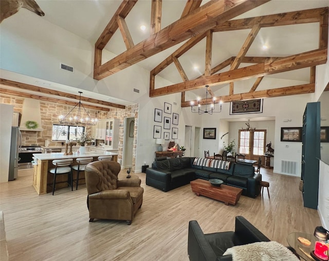 living room with an inviting chandelier, visible vents, and light wood-style floors